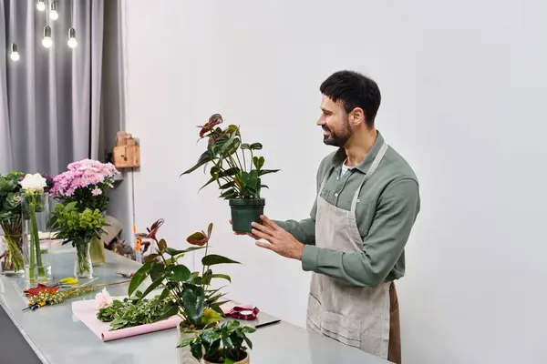 A skilled florist lovingly showcases vibrant plants in his charming shop filled with flowers. — Stock Photo