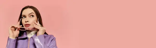 Beautiful woman adjusts her sunglasses while showcasing a fashionable look in a vibrant setting. — Stock Photo
