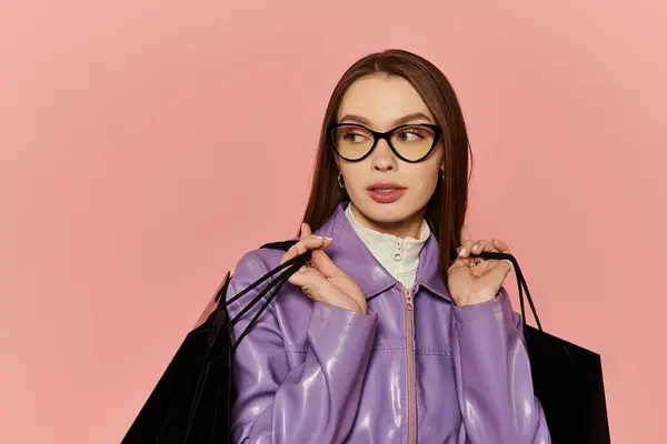 Belle femme exhibe son look élégant tout en portant des sacs à provisions dans un cadre vibrant. — Photo de stock