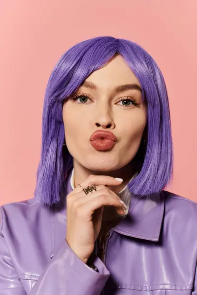A stylish woman with vibrant purple hair playfully poses against a bright pink background. — Stock Photo