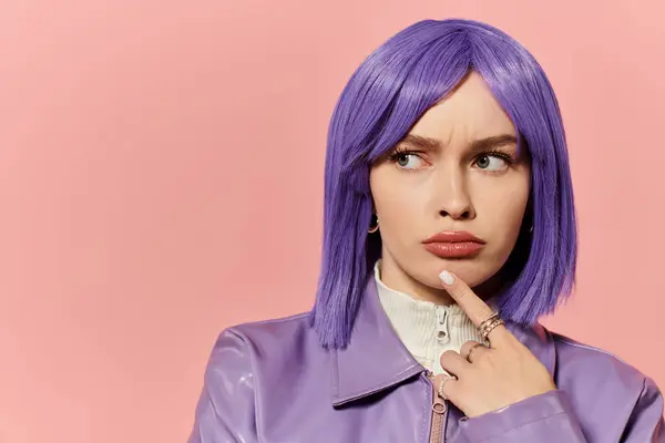 Une femme élégante aux cheveux violets pose avec soin sur un fond rose. — Photo de stock