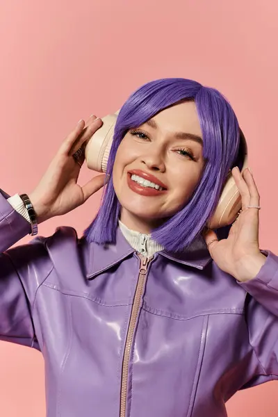A vibrant stylish woman smiles while wearing oversized headphones and enjoying her favorite music. — Stock Photo