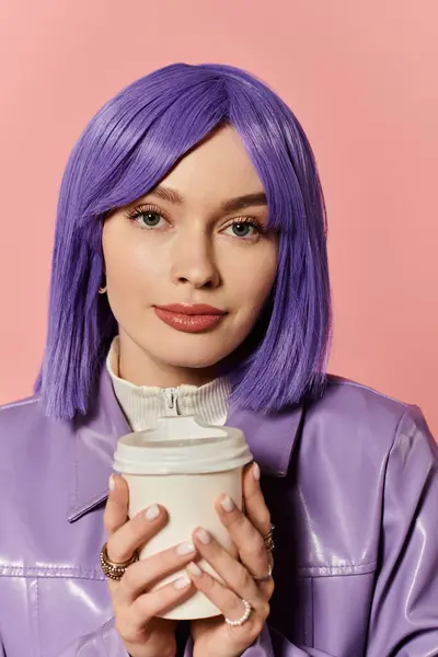 Stylish woman with purple hair enjoys a drink in a vibrant pink backdrop setting. — Stock Photo