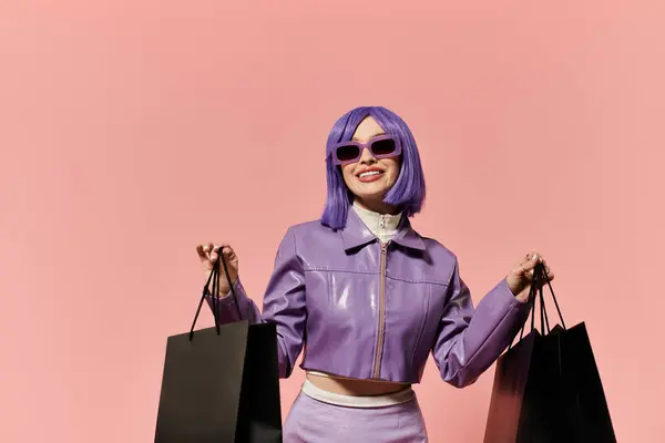 Una mujer vibrante con una peluca púrpura sonríe alegremente mientras sostiene bolsas de compras. - foto de stock