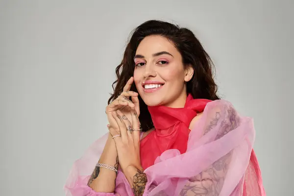 A young beautiful woman is joyfully posing with a playful smile, showcasing her colorful attire. — Stock Photo