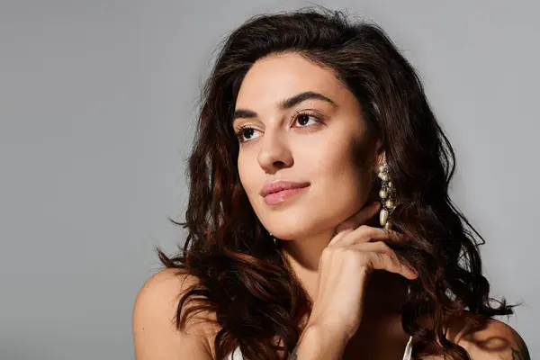 Portrait of a young woman with flowing hair, wearing earrings, showcasing her beauty and grace. — Stock Photo