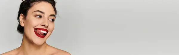Giovane donna luminosa e giocosa mostra un sorriso gioioso, mentre giocosamente sporgere la lingua — Foto stock