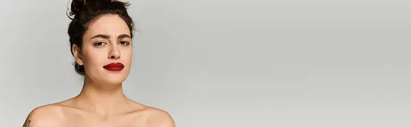 Giovane donna mostra fiducia con il suo trucco sorprendente e aspetto naturale in un ambiente minimalista. — Foto stock