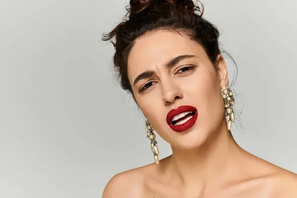 Young woman showcases bold lips and elegant earrings while expressing a confident look. — Stock Photo