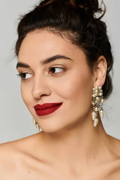 Beautiful woman showcasing bold makeup and stylish earrings, exuding confidence and charm. — Stock Photo