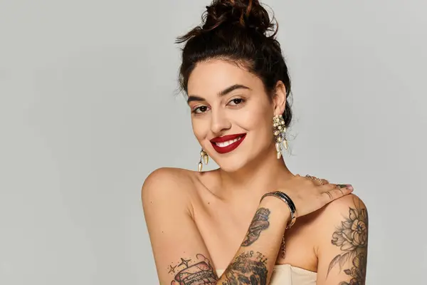 This young beautiful woman showcases her artistic tattoos and elegant smile while posing. — Stock Photo