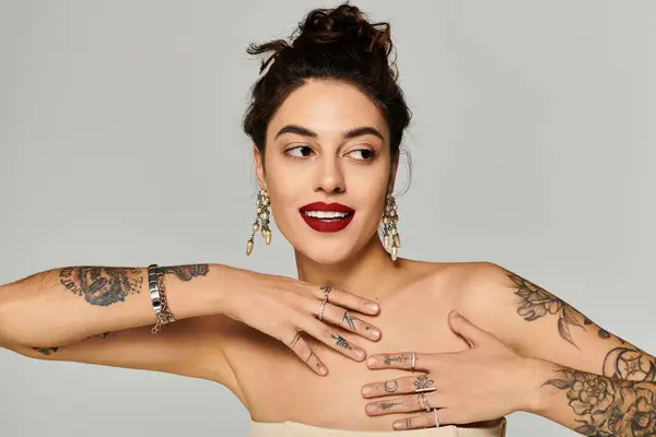 A young beautiful woman poses gracefully while displaying her exquisite jewelry collection. — Stock Photo