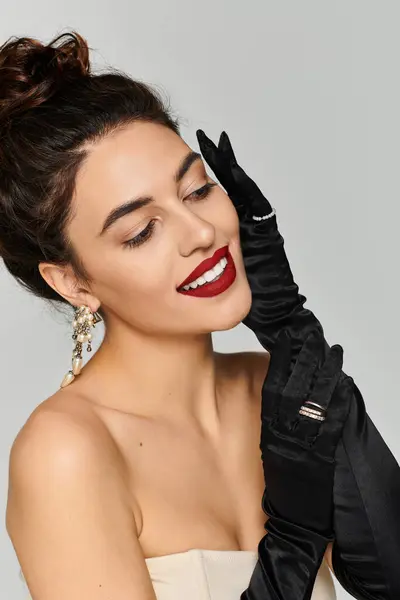 Young beautiful woman showcases her style with elegant gloves and bold red lipstick, smiling. — Stock Photo