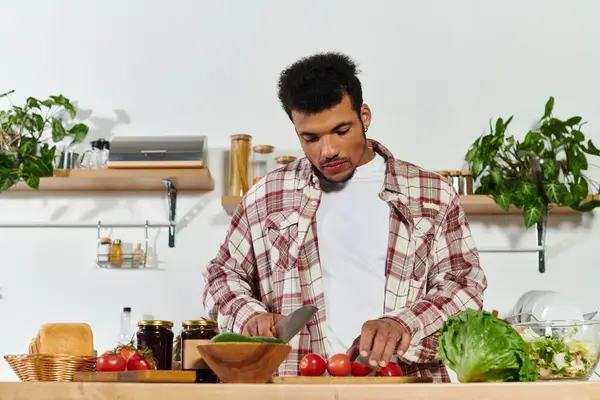 Handsome young man chopping vegetables in a contemporary kitchen, focused on healthy cooking. — Stock Photo