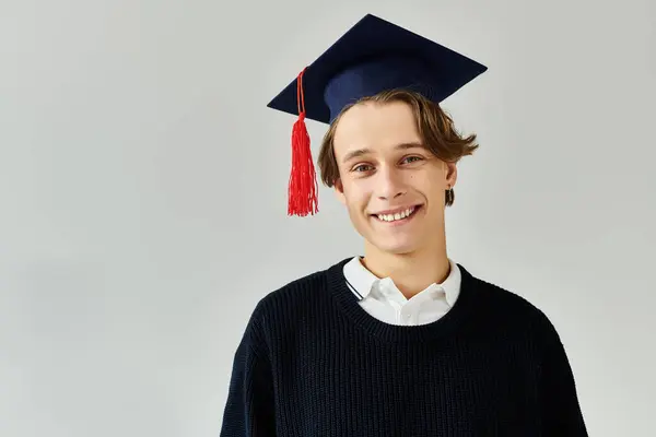 A young man smiles proudly in graduation cap, reflecting on his college journey and achievements. — Stock Photo