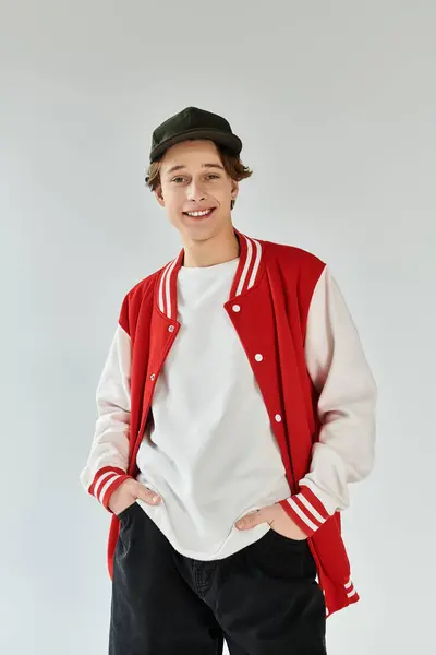 A young man in a bomber jacket poses confidently in a studio, reflecting modern youth culture. — Stock Photo
