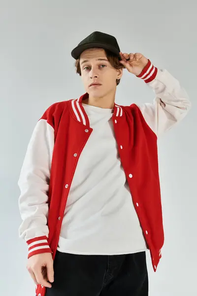 A stylish young student models his bomber jacket in a modern studio, embodying youth culture. — Stock Photo