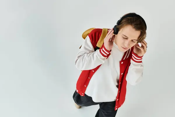 Um jovem bonito, vestido casualmente com uma jaqueta de bombardeiro elegante, mergulha na música. — Fotografia de Stock