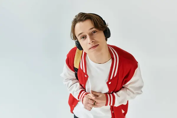 A handsome young man in a bomber jacket stands confidently, showcasing his stylish look. — Stock Photo