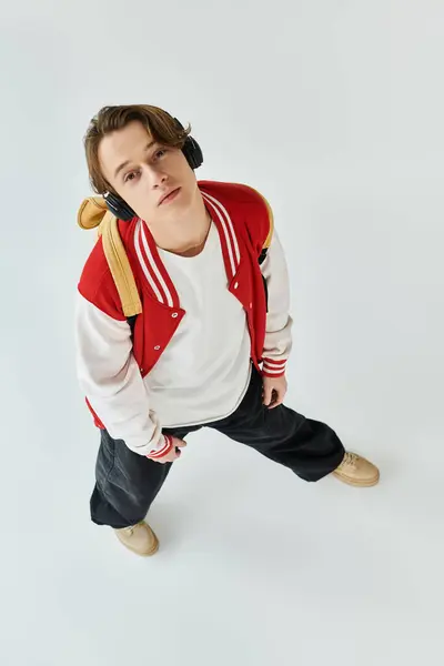 Um jovem na moda com uma jaqueta de bombista fica confiante em um estúdio, incorporando a cultura juvenil.. — Fotografia de Stock