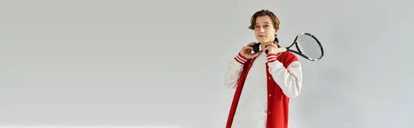 A young man exudes confidence in a trendy bomber jacket while holding a tennis racket. — Stock Photo