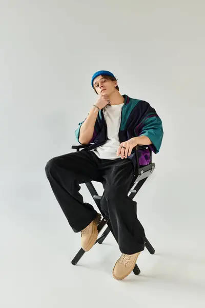 Confident young man poses in a stylish bomber jacket against a minimalist studio backdrop. — Stock Photo