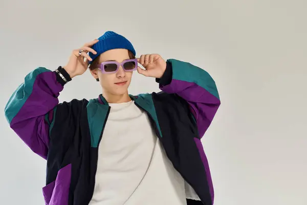 A handsome young man wearing a bomber jacket and beanie strikes a fashionable pose indoors. — Stock Photo