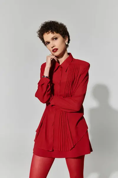 Woman showcases fashion sense in a striking red ensemble while exuding charm and elegance. — Stock Photo