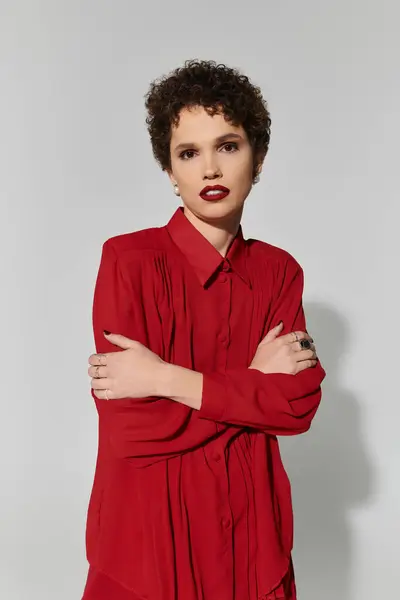 Une jeune belle femme respire la confiance en tenue rouge, mettant en valeur les tendances contemporaines de la mode. — Photo de stock