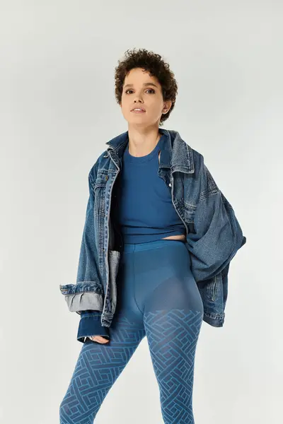 A confident young woman stands strikingly in a fashionable outfit, exuding style and comfort. — Stock Photo