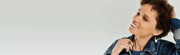 A young beautiful woman happily poses with a smile, showcasing her fashion sense in denim attire. — Stock Photo