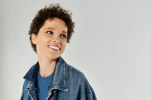 Une jeune femme rayonne de bonheur dans une veste en denim tendance, respirant la confiance. — Photo de stock