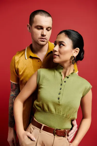 A young couple in trendy outfits expresses their affection in a vibrant studio setting. — Stock Photo
