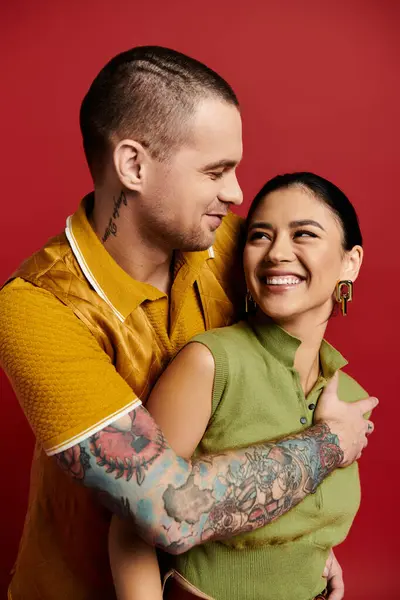 A young couple joyfully embraces in a studio, radiating romance and style for Valentines day. — Stock Photo