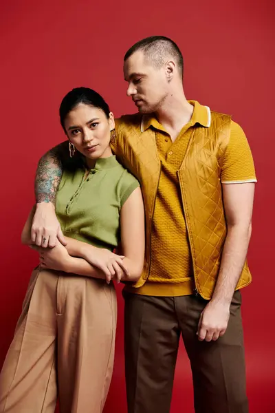 A young couple exudes romance, posing gracefully in fashionable attire against a bold backdrop. — Stock Photo