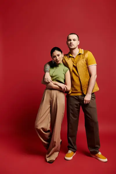 A young couple dressed in fashionable outfits stands together, expressing their love and connection. — Stock Photo