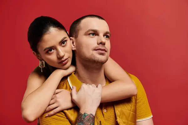 A beautiful young couple embraces in a trendy studio setting, celebrating love on Valentines Day. — Stock Photo