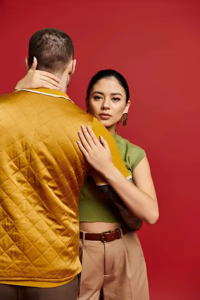A beautiful couple in trendy attire showcases their love against a vibrant backdrop. — Stock Photo