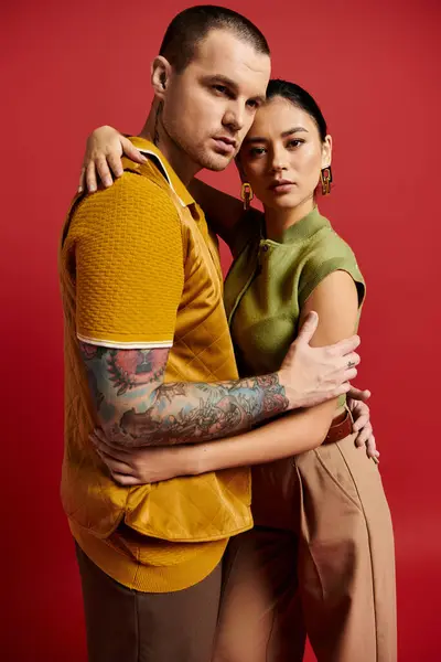 A beautiful young couple showcases their stylish outfits while expressing love in a studio. — Stock Photo