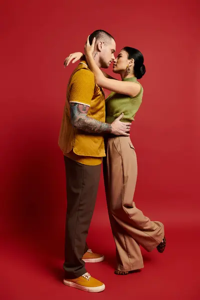 Una hermosa pareja joven se abraza apasionadamente, mostrando amor y moda. - foto de stock