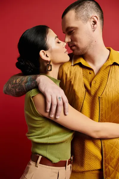 A young couple shares a romantic moment in a studio, showcasing their fashionable outfits. — Stock Photo