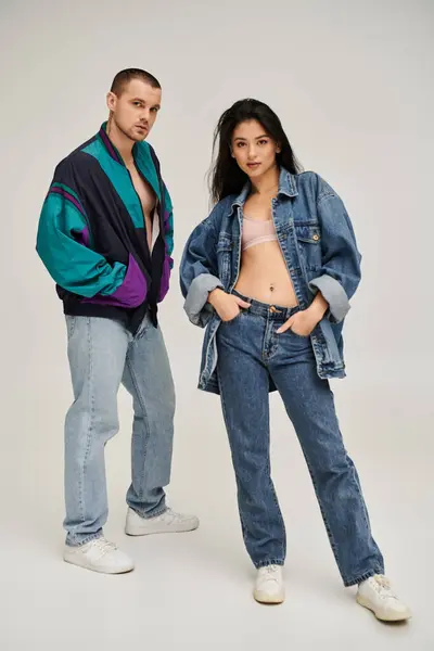 A stylish young couple poses confidently in a studio — Stock Photo