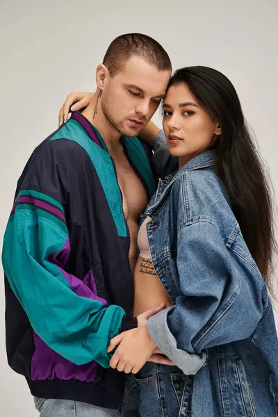 A beautiful couple embraces in a studio, showcasing their stylish outfits and love for each other. — Stock Photo