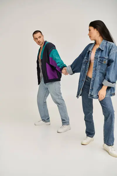 A beautiful young couple dressed in trendy outfits enjoys their time together, showcasing love. — Stock Photo