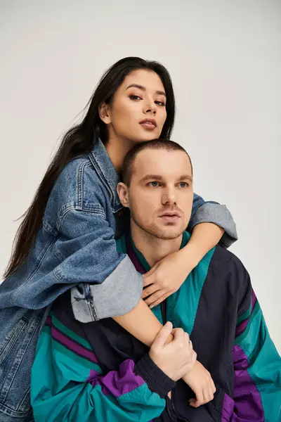 A beautiful young couple shares a moment of love in a studio, dressed in trendy attire. — Stock Photo