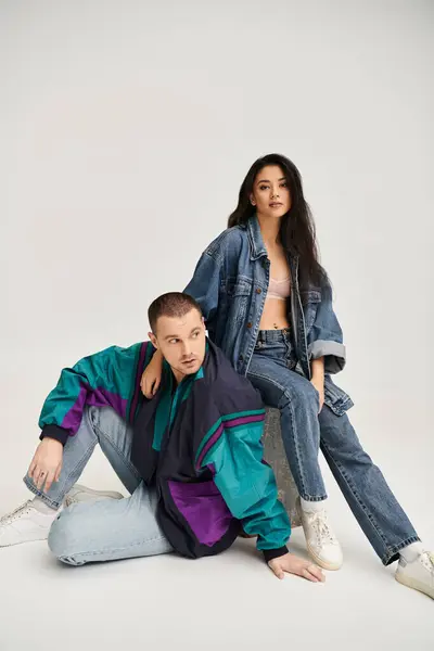 Young couple dressed in trendy outfits expresses their love in a studio, capturing romance. — Stock Photo