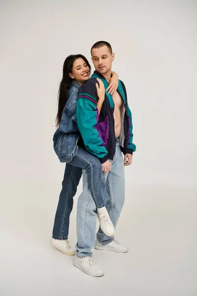 A beautiful couple poses together in stylish outfits, sharing an affectionate moment. — Stock Photo