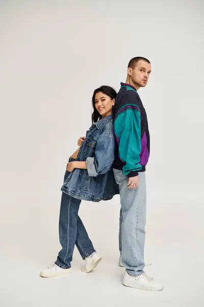 A beautiful couple dressed in trendy outfits shares a joyful moment in a studio, radiating love. — Stock Photo