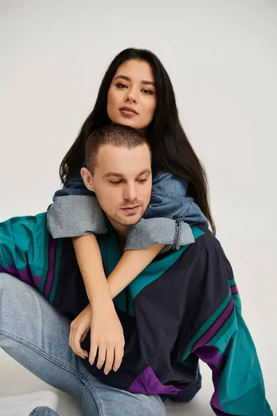 A young couple dressed in fashionable attire embraces, showcasing their love and connection. — Stock Photo