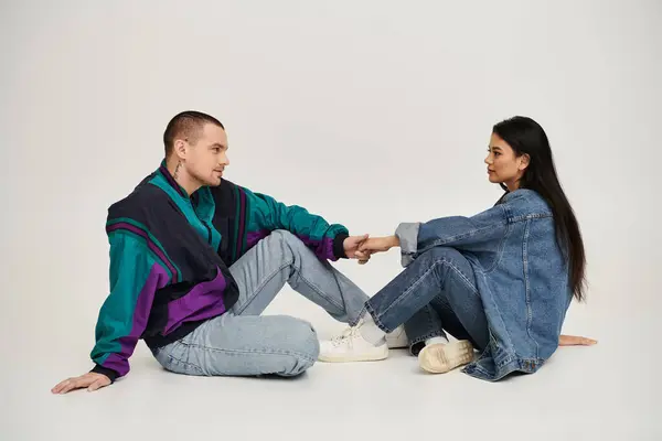 A young couple holds hands in a cozy studio, showing their love and romance. — Stock Photo